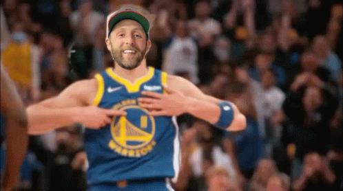 A Man Wearing A Golden State Warriors Jersey Is Pointing At His Chest . GIF