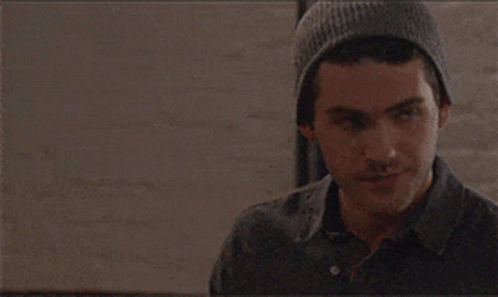 A Man Wearing A Gray Beanie Looks To His Left GIF
