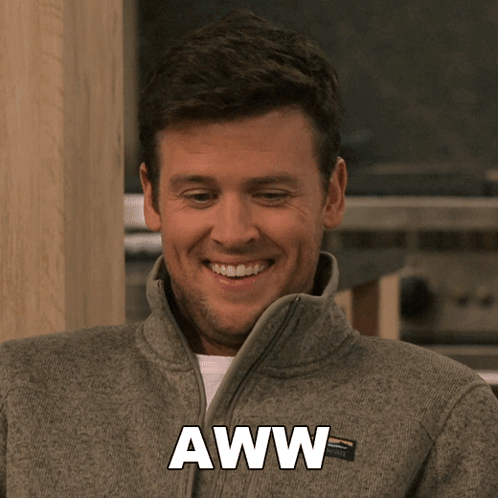 A Man Wearing A Gray Jacket With The Word Aww Written On It GIF