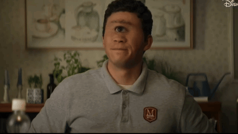 A Man Wearing A Gray Shirt With The Letter M On The Front GIF