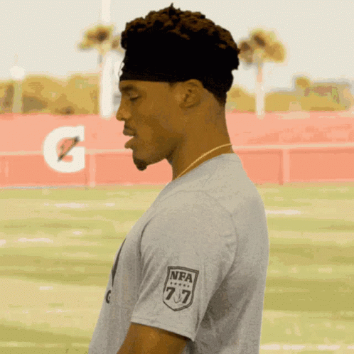 A Man Wearing A Gray T-Shirt With The Nfl Logo On His Sleeve GIF
