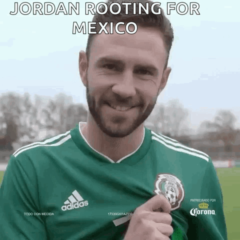 A Man Wearing A Green Adidas Jersey Is Holding A Trophy . GIF