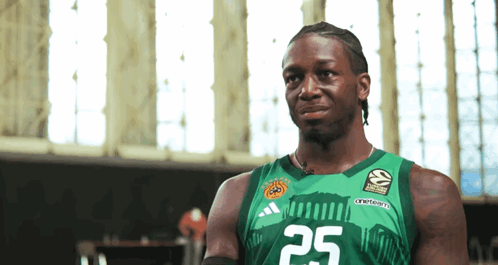 a man wearing a green adidas jersey with the number 25 on it