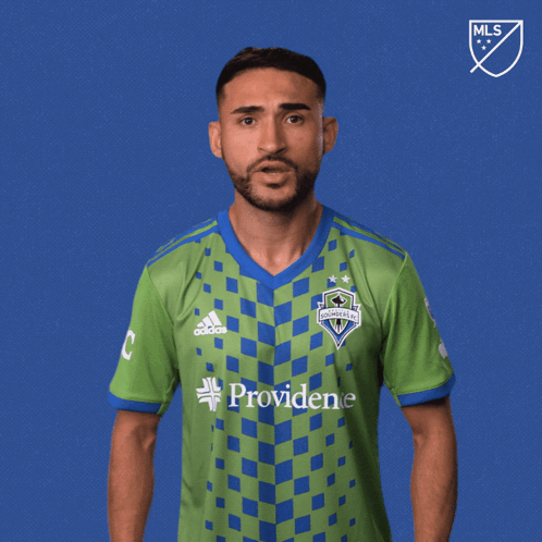 A Man Wearing A Green And Blue Shirt With The Word Vamos On It GIF
