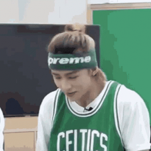 A Man Wearing A Green Celtics Jersey And A Green Headband Is Looking Down . GIF