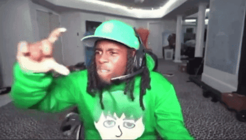 A Man Wearing A Green Hoodie And A Blue Hat Is Giving A Thumbs Up GIF