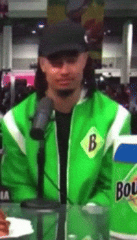 a man wearing a green jacket with the letter b on the front