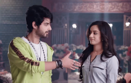 A Man Wearing A Green Jacket With The Letters Ff On The Sleeves Talks To A Woman GIF