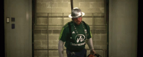 A Man Wearing A Green Leatherman Shirt And A Hard Hat GIF