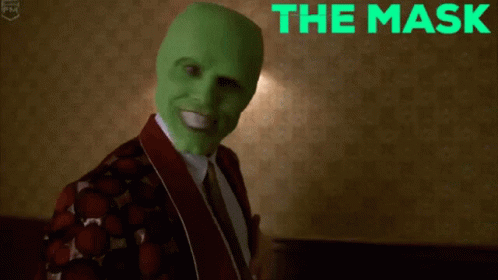 A Man Wearing A Green Mask Is Smiling With The Words The Mask Behind Him GIF