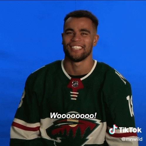 A Man Wearing A Green Minnesota Wild Jersey Says Woooooo GIF