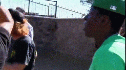 A Man Wearing A Green Shirt And A Hat With The Letter N On It GIF
