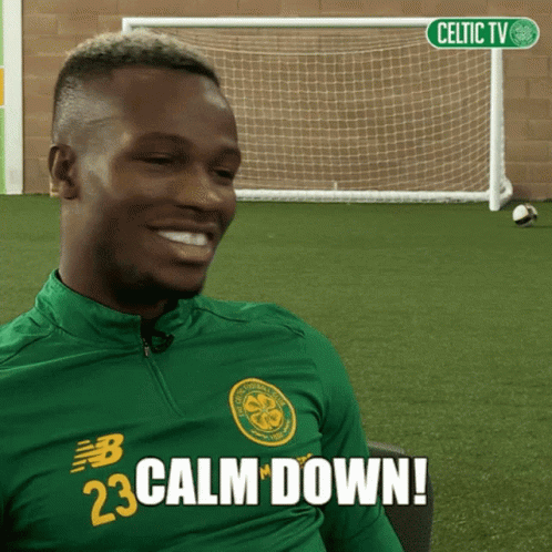 A Man Wearing A Green Shirt That Says Calm Down On It GIF