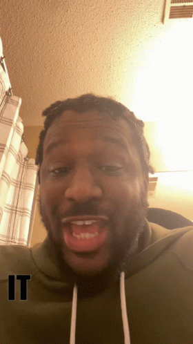 A Man Wearing A Green Sweatshirt With The Word " It " On The Bottom GIF