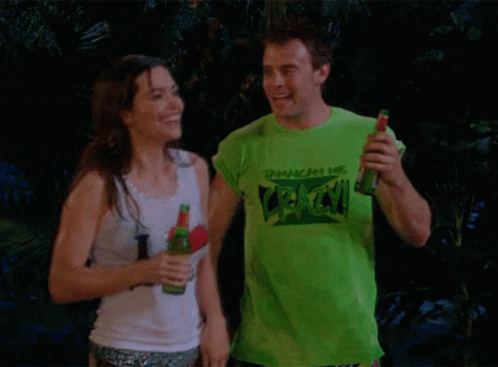 A Man Wearing A Green T-Shirt That Says " Crack " Holds A Bottle Of Beer Next To A Woman GIF