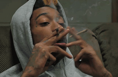 A Man Wearing A Grey Hoodie Smoking A Cigarette GIF