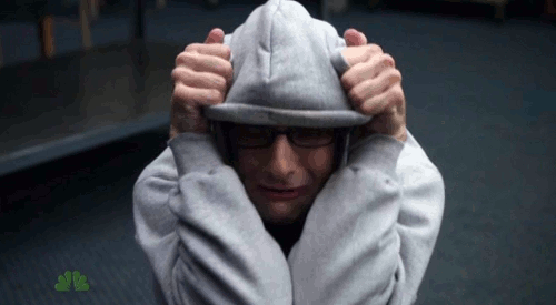 A Man Wearing A Grey Hoodie With A Nbc Logo Behind Him GIF