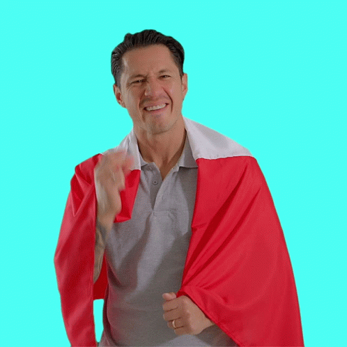 A Man Wearing A Grey Shirt And A Red And White Cape GIF