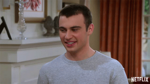 Man Smiling In Front Of Netflix Logo GIF