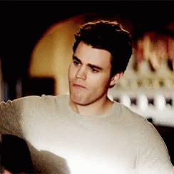 A Man Wearing A Grey Sweater Looks At Something GIF