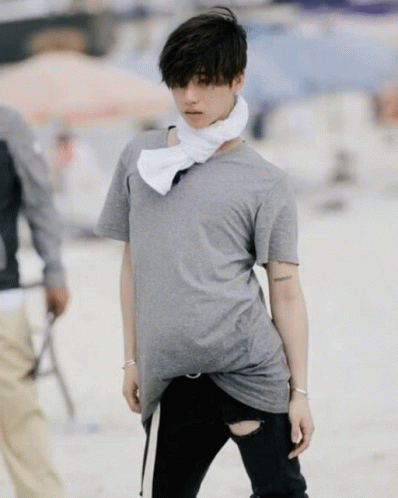 A Man Wearing A Grey T-Shirt And Black Ripped Jeans GIF