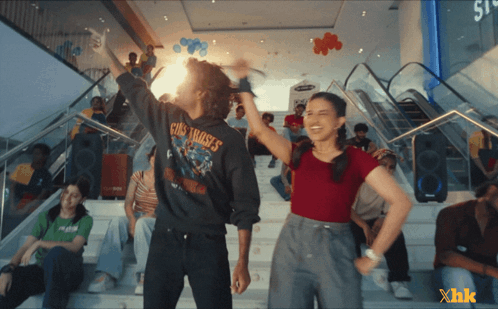 A Man Wearing A Guns N ' Roses Shirt Is Standing Next To A Girl GIF