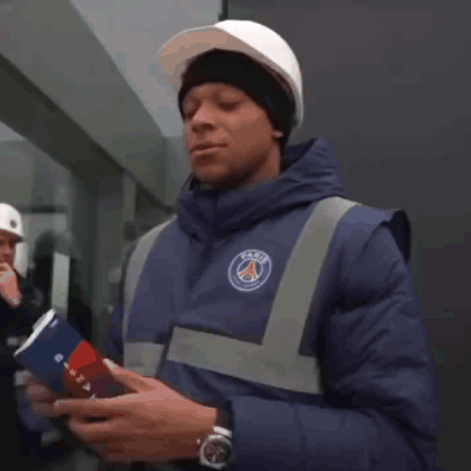 A Man Wearing A Hard Hat And A Blue Jacket With The Word Paris On It GIF