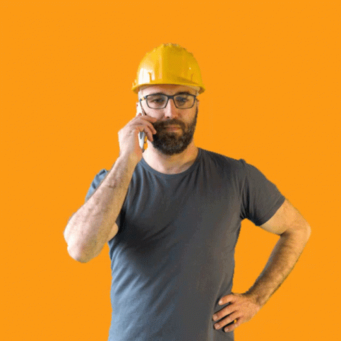 A Man Wearing A Hard Hat And Glasses Talking On A Cell Phone GIF
