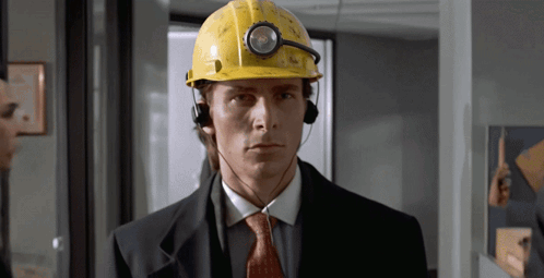 A Man Wearing A Hard Hat And Headphones Looks Serious GIF
