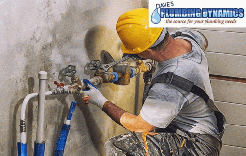 A Man Wearing A Hard Hat Is Working On A Pipe With Dave 'S Plumbing Dynamics Written On The Bottom GIF