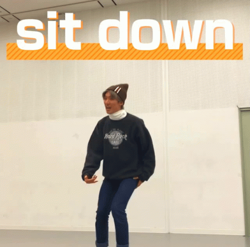 A Man Wearing A Hard Rock Cafe Sweatshirt Is Squatting GIF