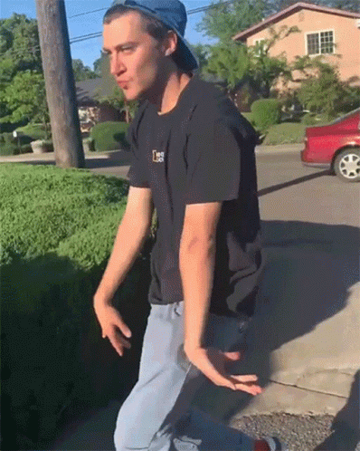 A Man Wearing A Hat And A Black Shirt With The Letter L On The Front GIF
