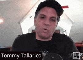 A Man Wearing A Hat And A Black Shirt With The Name Tommy Tallarico On The Bottom GIF