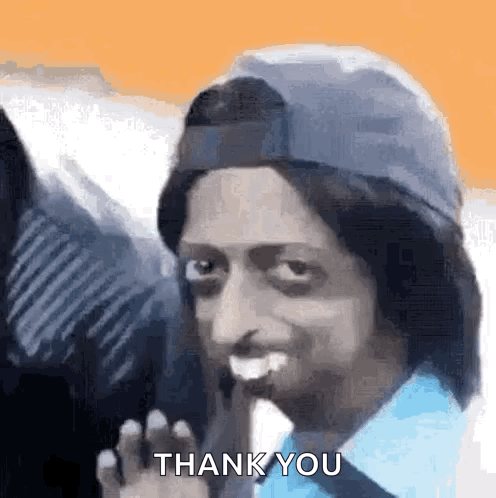 A Man Wearing A Hat And A Blue Shirt Is Giving A Thank You Gesture . GIF