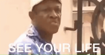 A Man Wearing A Hat And A Blue Shirt Is Standing In Front Of A Clock And Says `` See Your Life '' . GIF