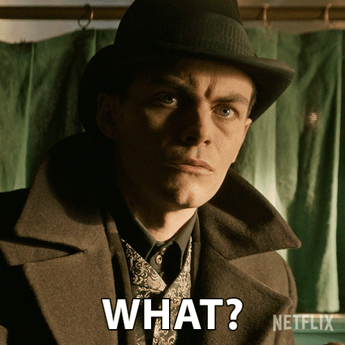 A Man Wearing A Hat And A Coat Is Asking What GIF