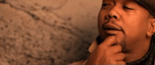 A Man Wearing A Hat And A Coat Is Thinking About Something GIF