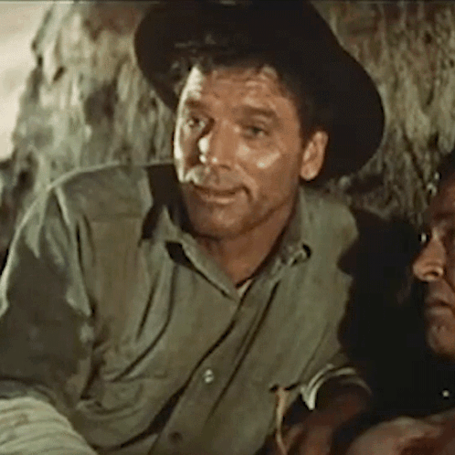 A Man Wearing A Hat And A Green Shirt Is Sitting Next To Another Man GIF
