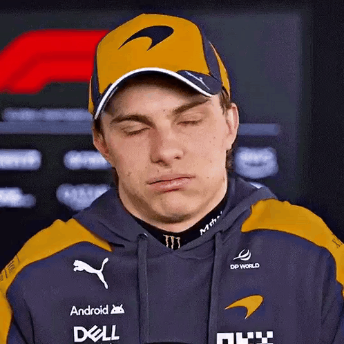 A Man Wearing A Hat And A Hoodie Is Making A Funny Face With His Eyes Closed . GIF