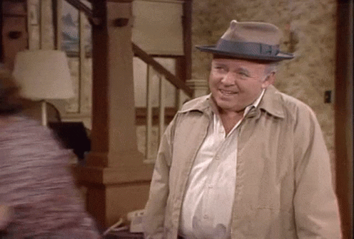 Man Smiling In Living Room With Hat And Jacket GIF