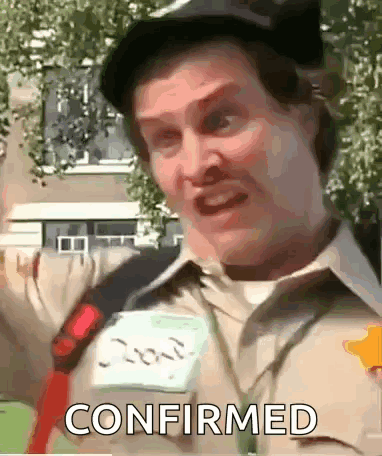 A Man Wearing A Hat And A Name Tag That Says Confirmed On It . GIF