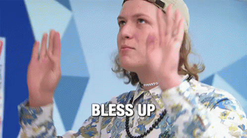 A Man Wearing A Hat And A Necklace Is Giving A High Five And Says Bless Up GIF
