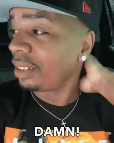 A Man Wearing A Hat And A Necklace Says Damn On His Face GIF