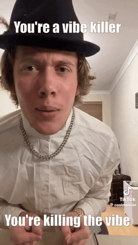 A Man Wearing A Hat And A Necklace Says You 'Re A Vibe Killer You 'Re Killing The Vibe GIF