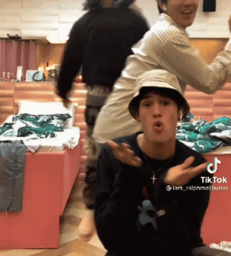 A Man Wearing A Hat And A Necklace With A Cross On It Has A Tiktok Sticker On His Chest GIF