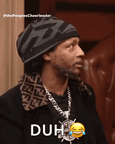 A Man Wearing A Hat And A Necklace With The Word Duh On It GIF