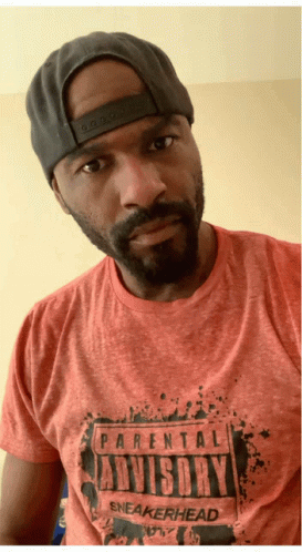 A Man Wearing A Hat And A Parental Advisory Sneakerhead Shirt GIF