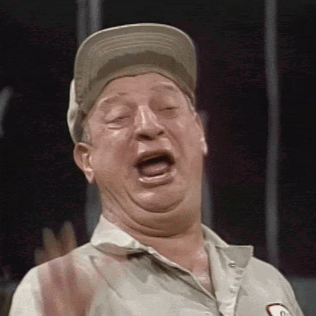 A Man Wearing A Hat And A Shirt Is Making A Funny Face With His Mouth Open . GIF
