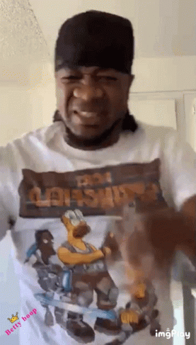 a man wearing a hat and a t-shirt with a picture of homer simpson on it .