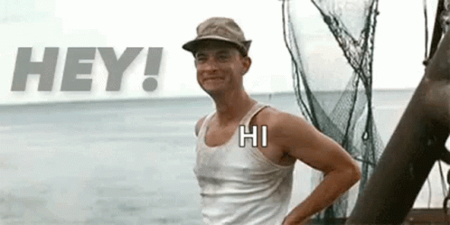 A Man Wearing A Hat And A Tank Top Is Standing In Front Of A Boat In The Ocean . GIF